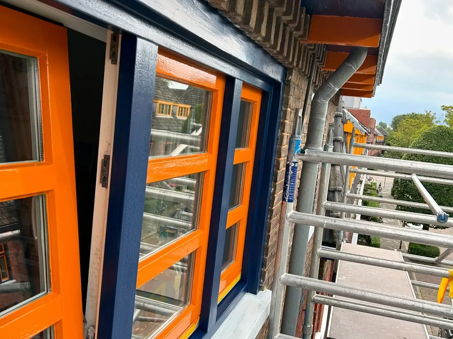 Open kozijn met oranje roeden in een donkerblauw kader