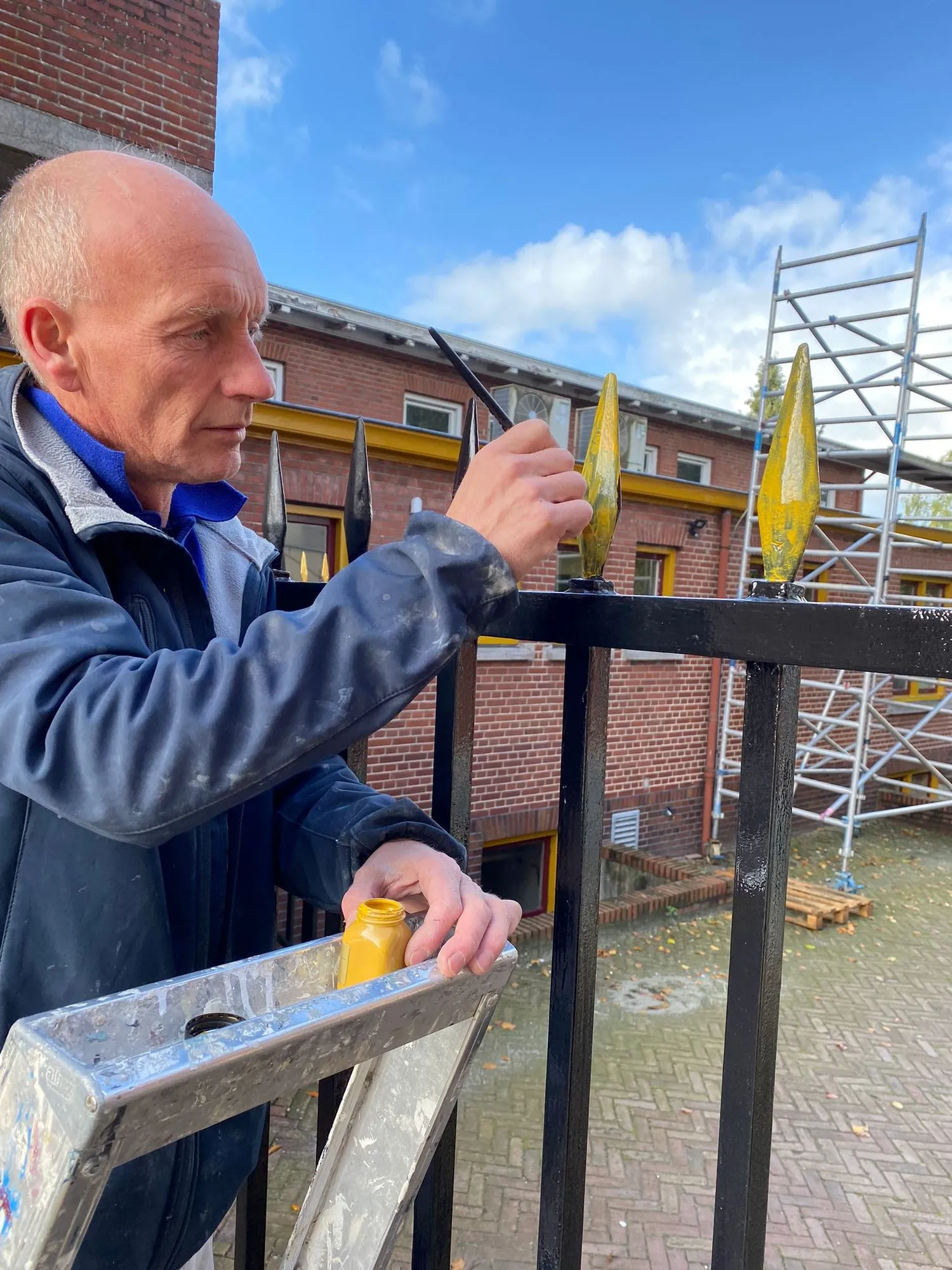 David verguldt de speerpunt van een hek