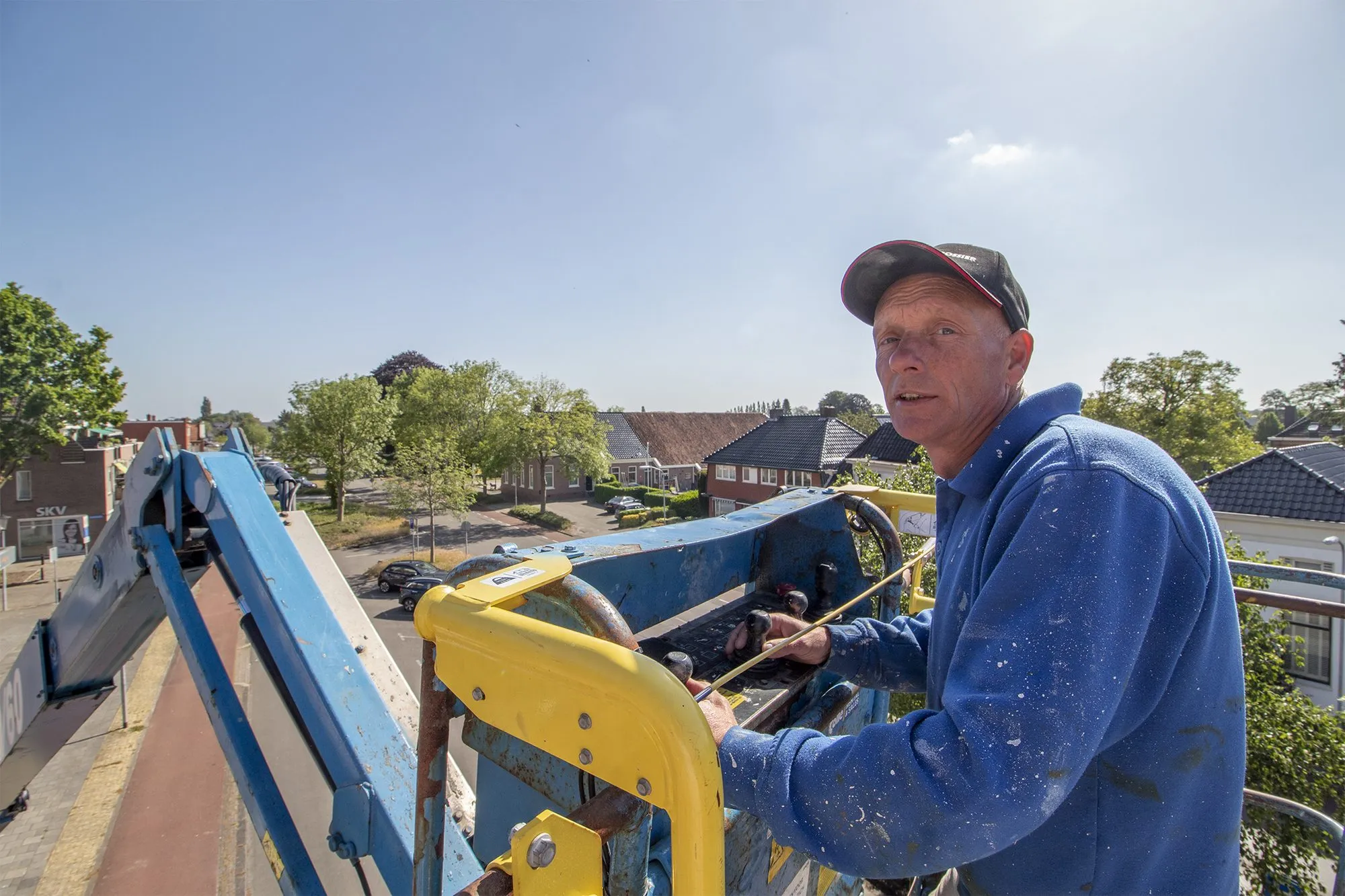 David op een hoogwerker bij een gevel