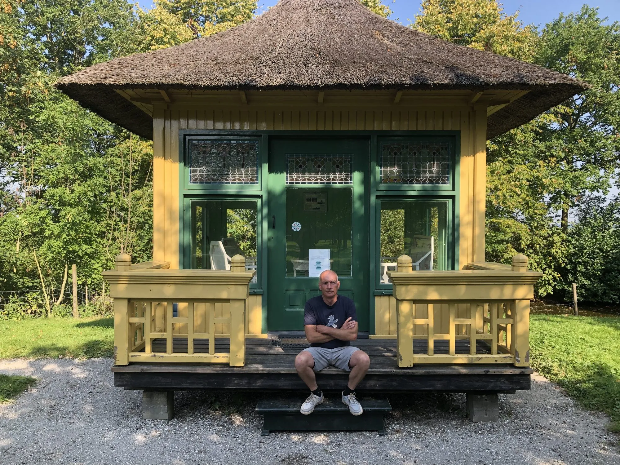 David zit op de trap van een geschilderd tuinprieel