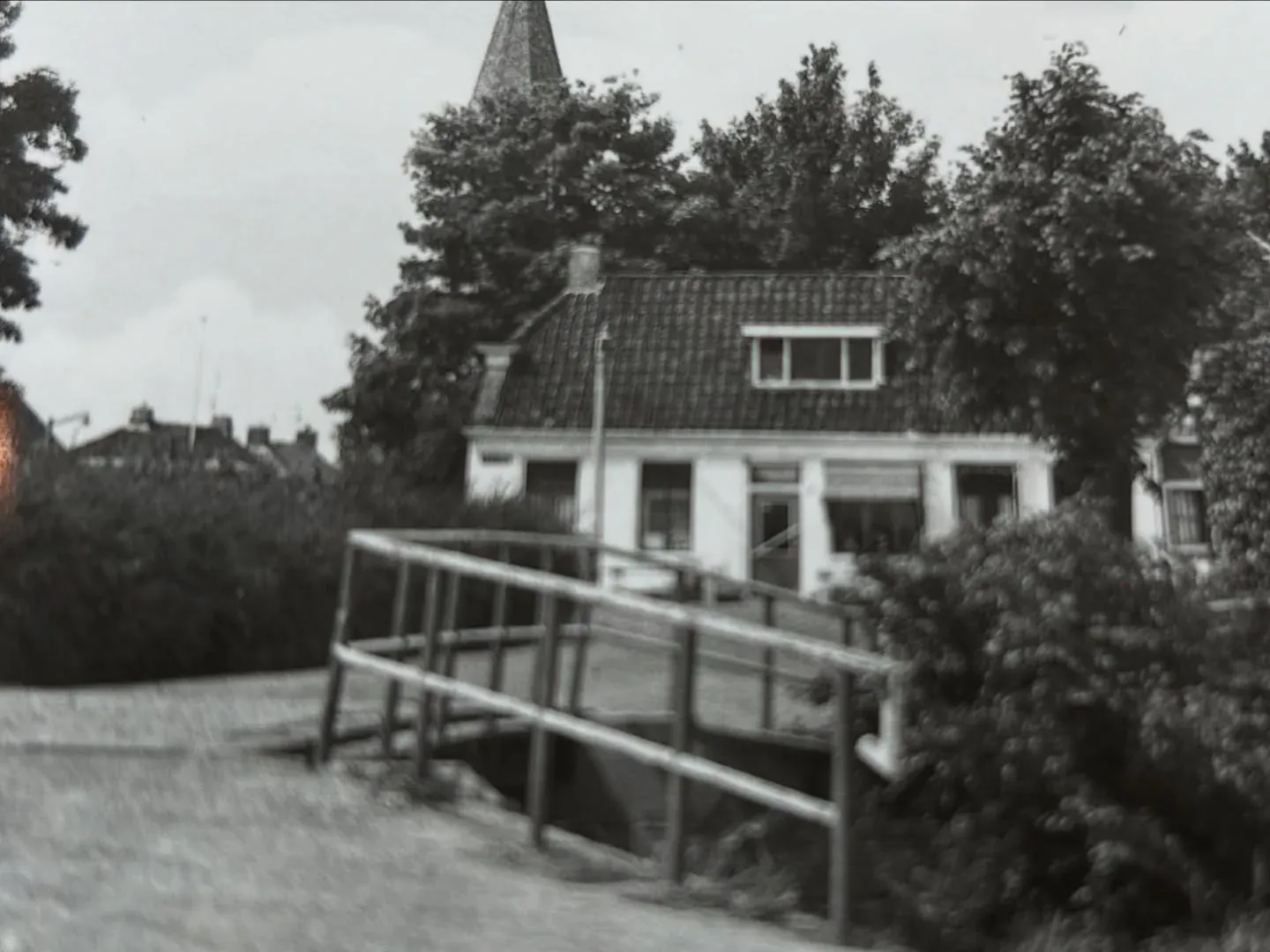 Oude zwart-witfoto van de bakkerij met het bruggetje ervoor