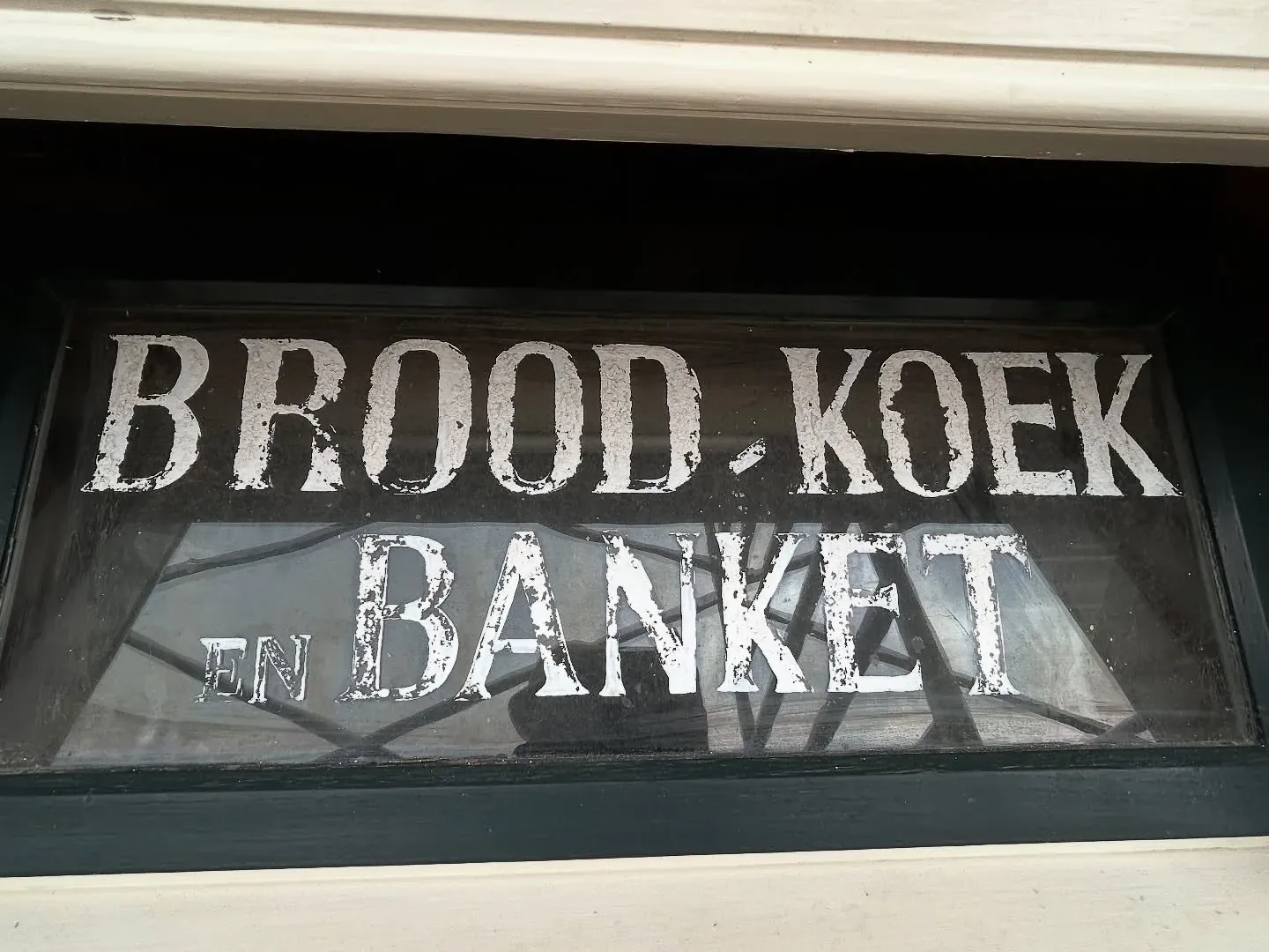 Verweerd gevelopschrift met de woorden BROOD KOEK EN BANKET