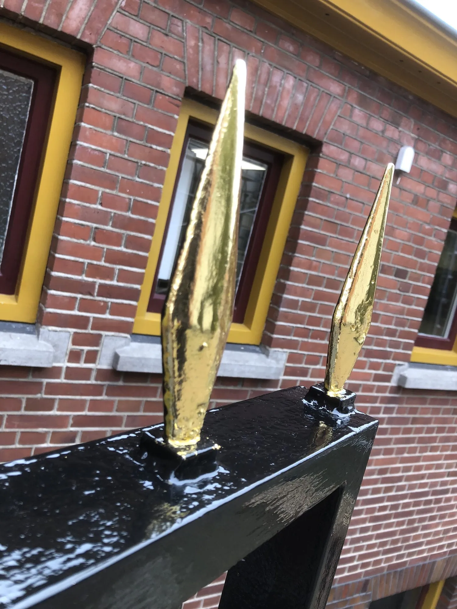 Vergulde speerpunten op een zwart hekwerk