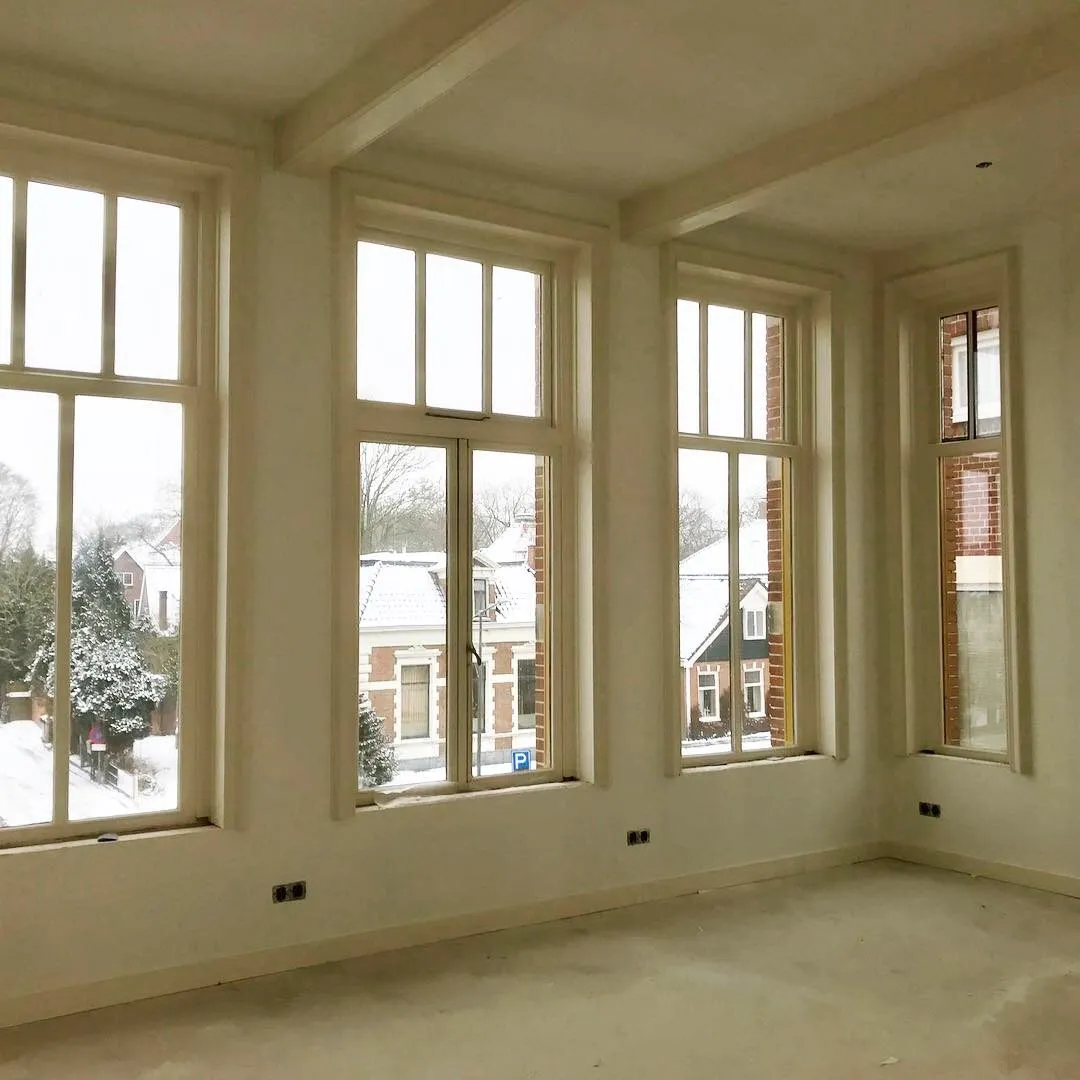 Kamer met hoge schuiframen en daglicht