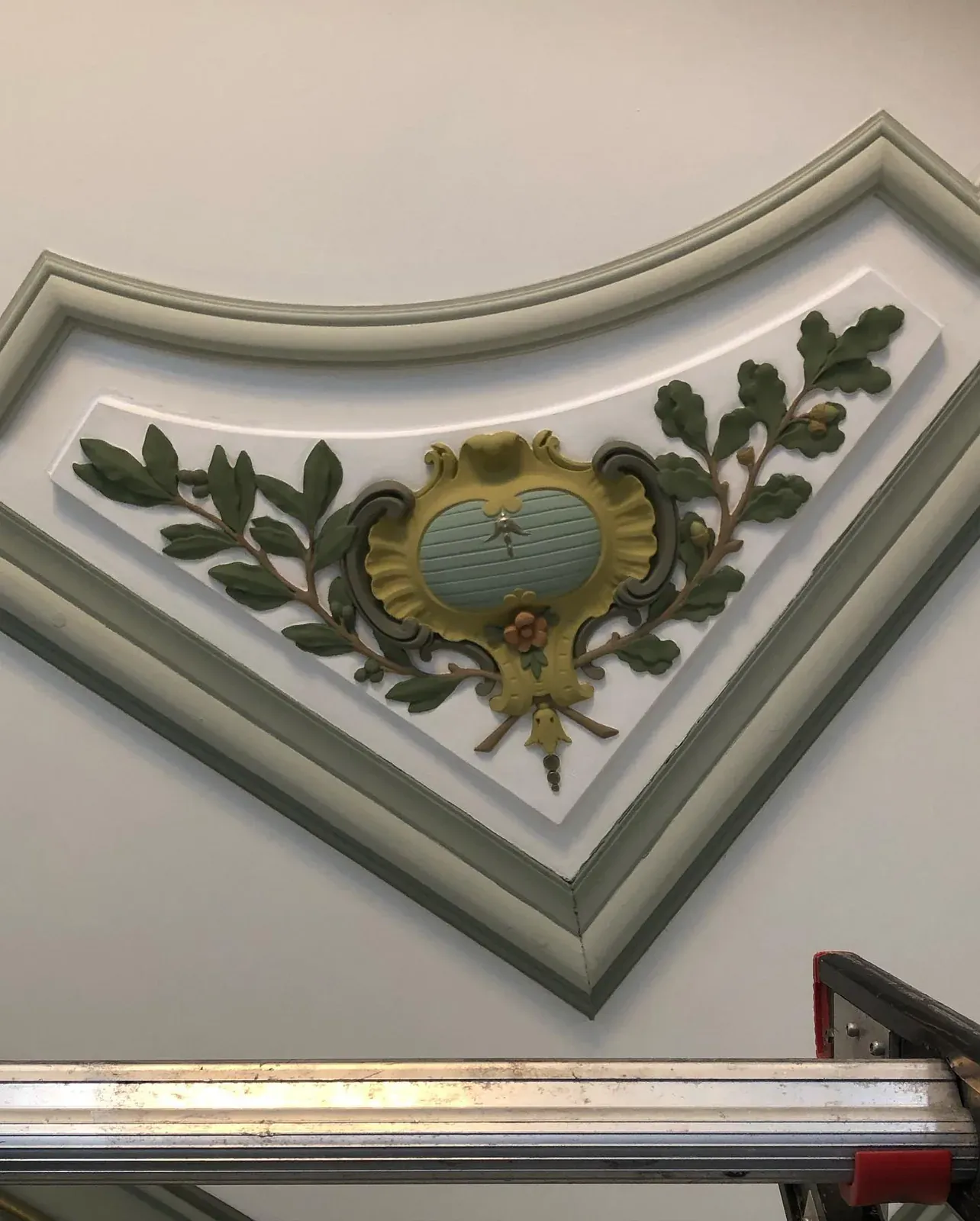 Plafondornament met eikenbladeren rond een cartouche, in kleur teruggebracht