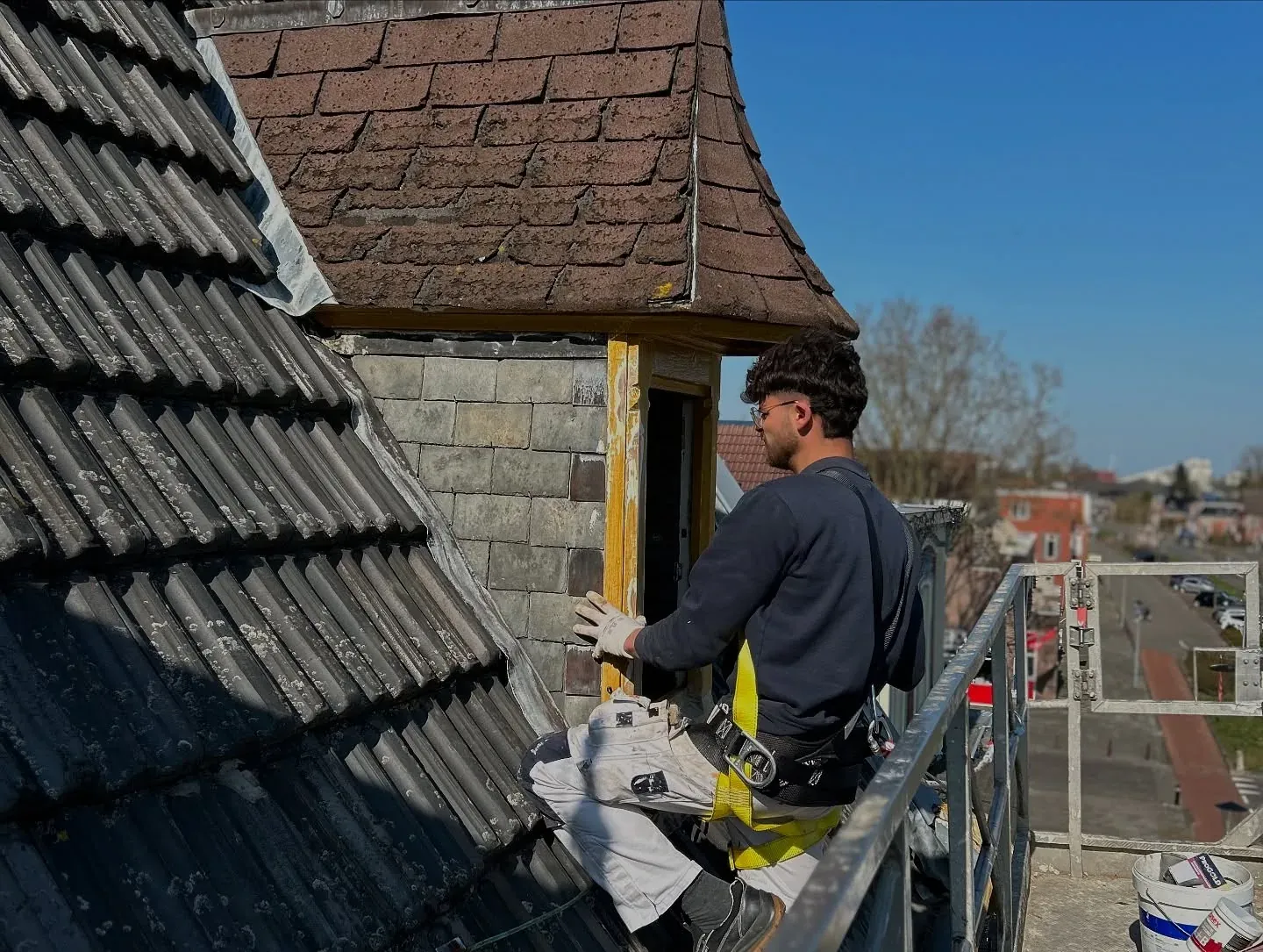 Schilder werkt vanaf de dakrand aan een dakkapel