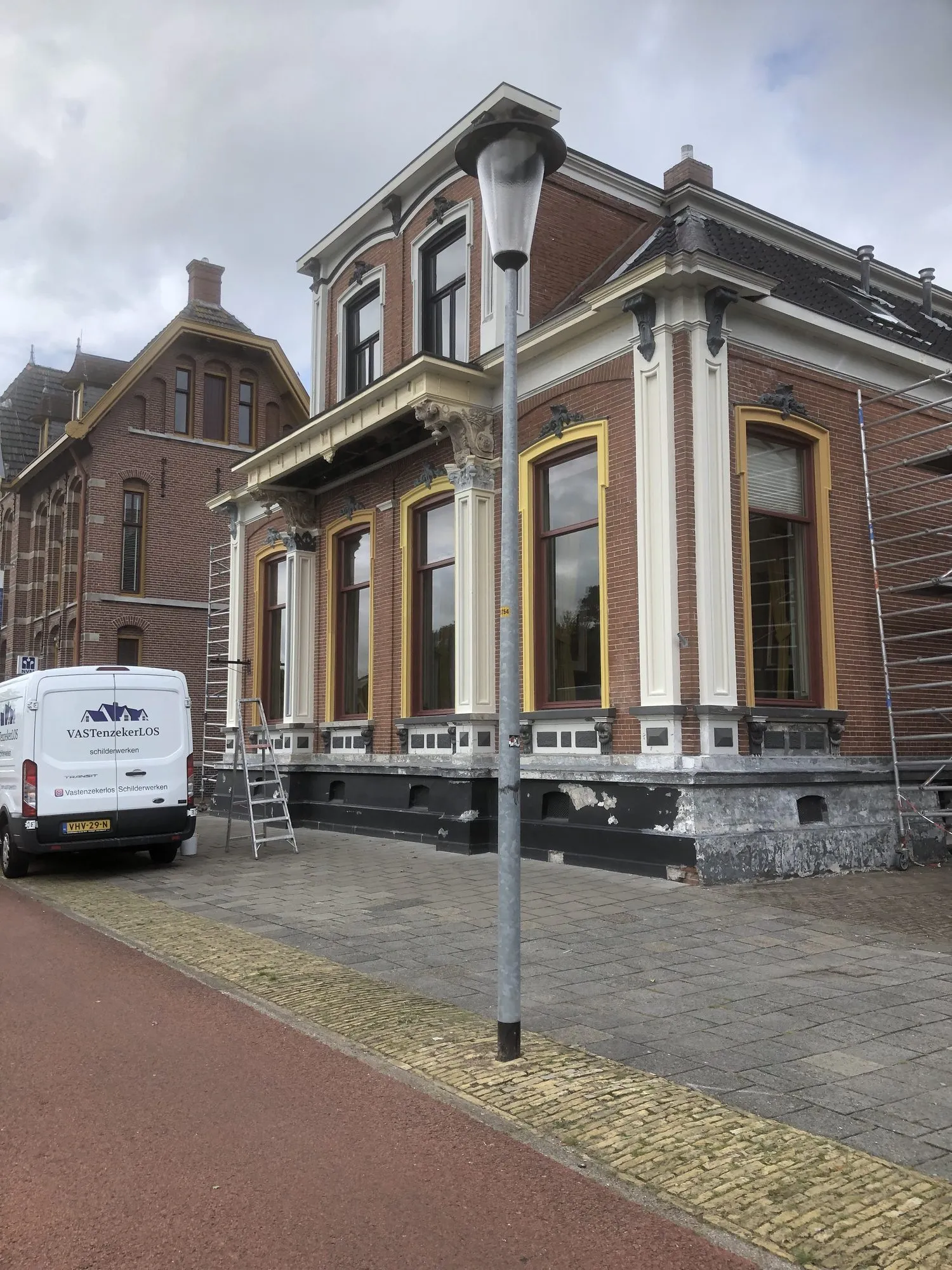 Het herenhuis gezien vanaf de straat, met okergele accenten in de kozijnen