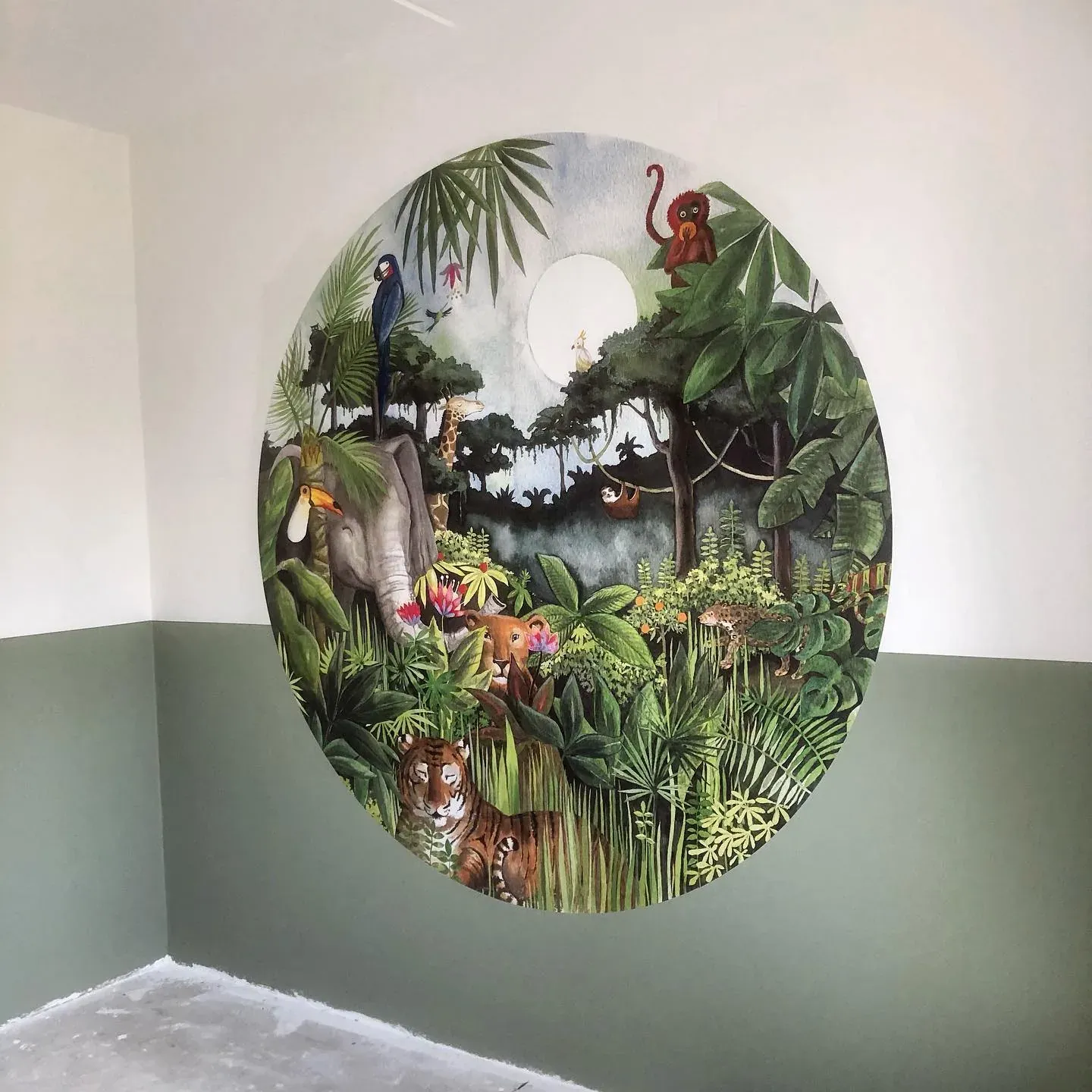 Ronde muurschildering met een jungle vol dieren op een groengrijze wand
