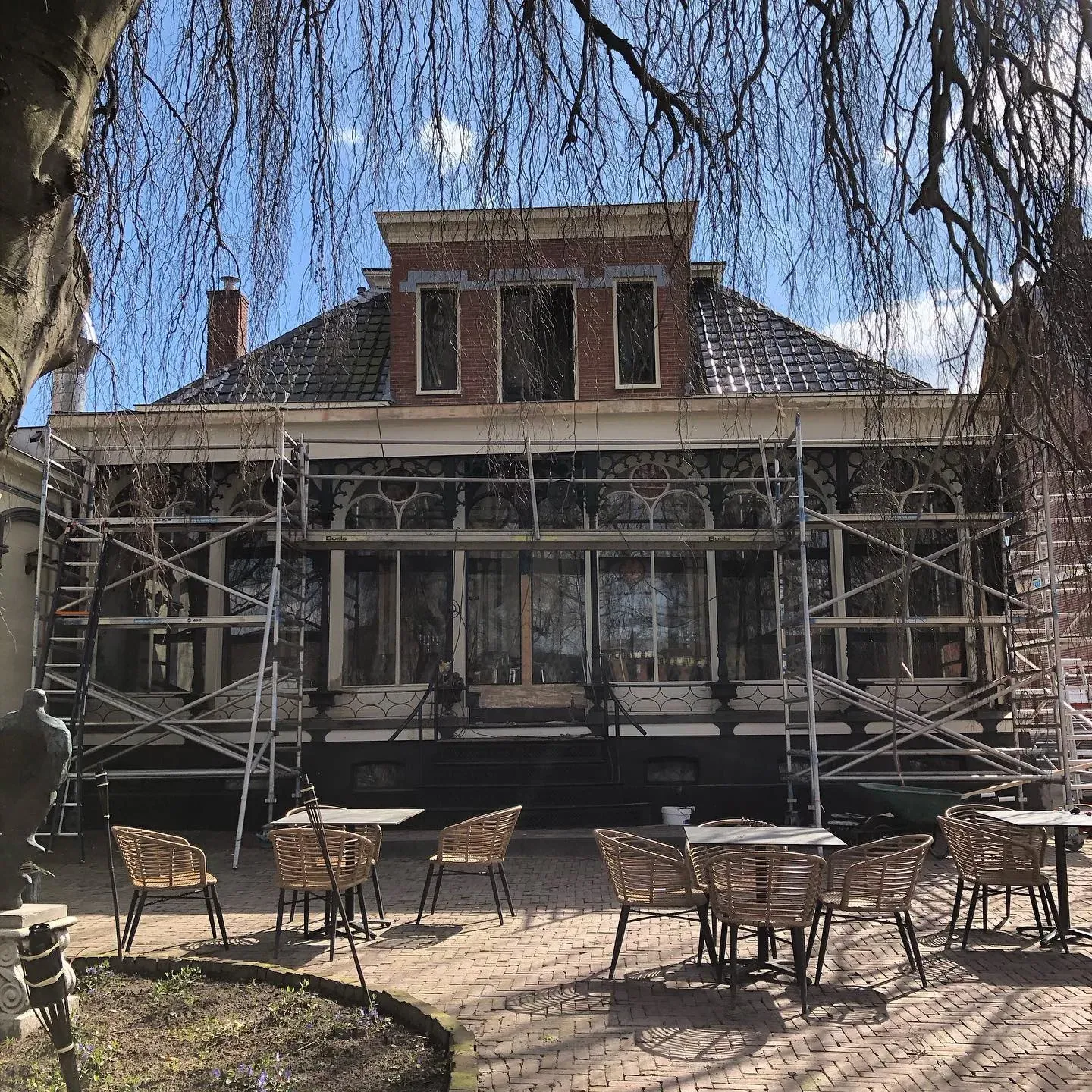 Villa met veranda in de steigers, onder een treurwilg
